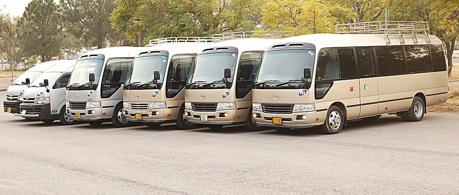 A row of Amber Tours Hiace vans and Coasters parked together in Islamabad